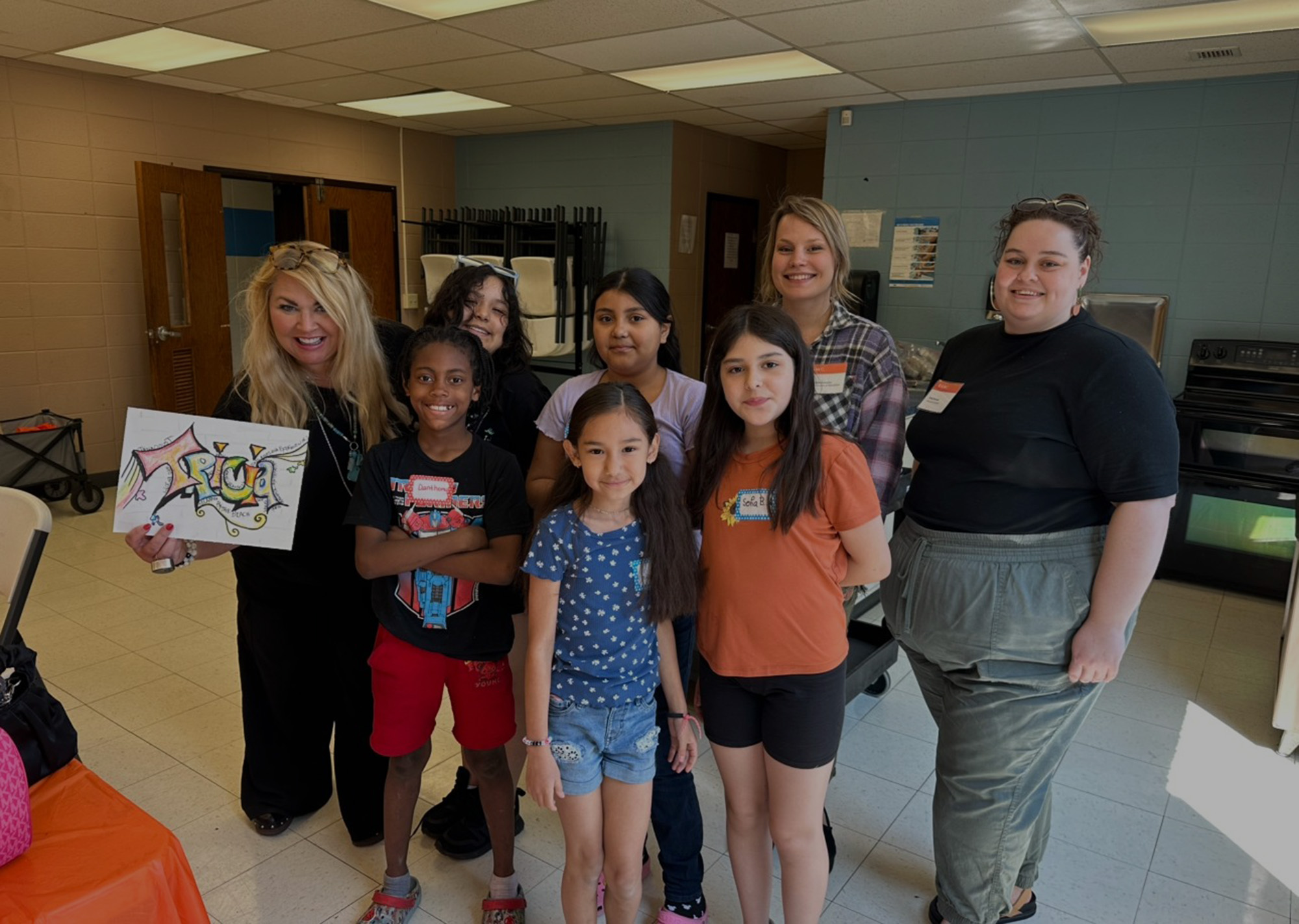 Kids and volunteers pose for a picture