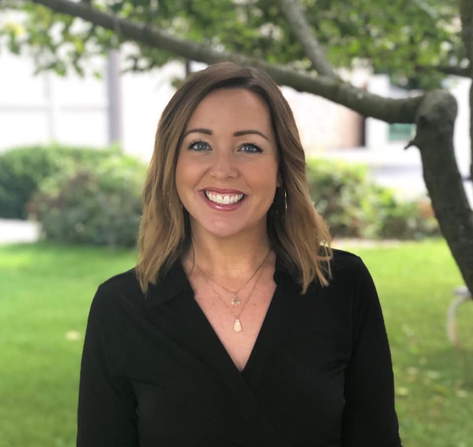 Photo of United Way of Racine County President and CEO Ali Haigh, a grinning white woman with brunette hair to her shoulders.