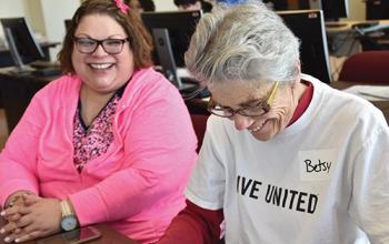 A VITA volunteer assists someone with their taxes.