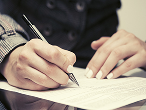 A person writing on a piece of paper.