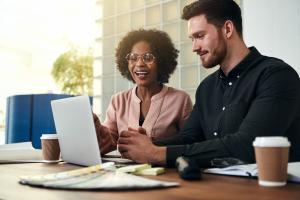 Two people sitting at a laptop